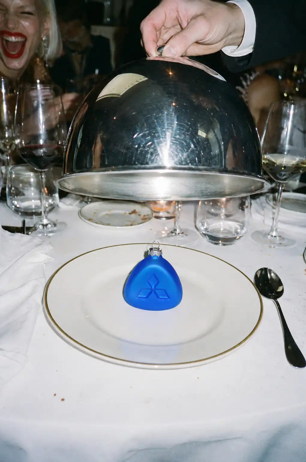 Blauw Nachtglas-ornament De Blauwe op een wit bord onder een zilveren cloche tijdens een diner